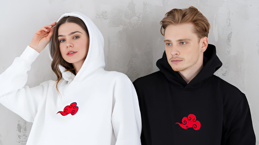 Man and woman wearing white and black hoodies with red Akatsuki cloud logo, anime-inspired streetwear for fans.